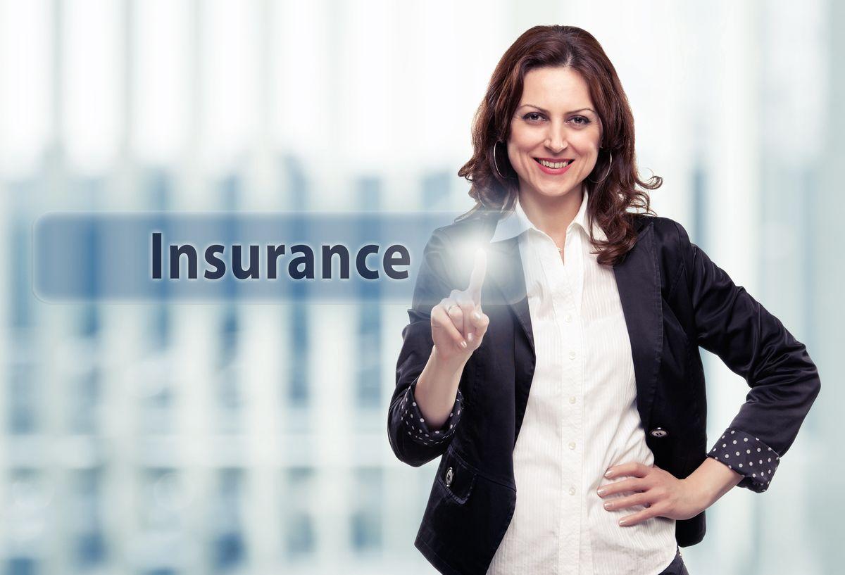 Business woman pressing Insurance button at her office. Toned photo.